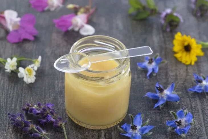 Баночка маточного молочка с пластиковой ложечкой и цветами