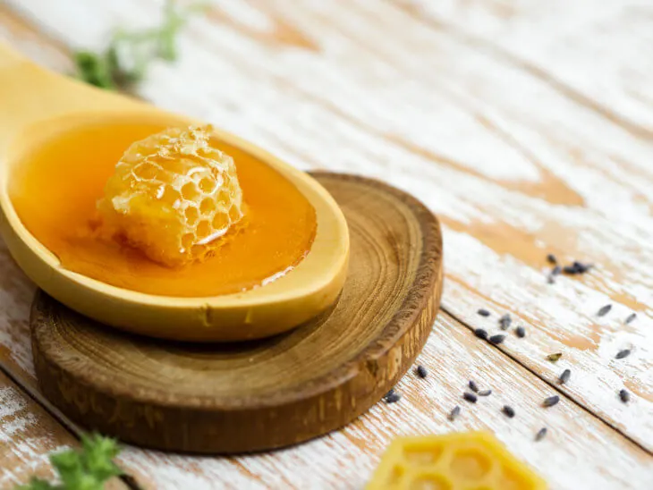 Деревянная ложка с медом и кусочком сот