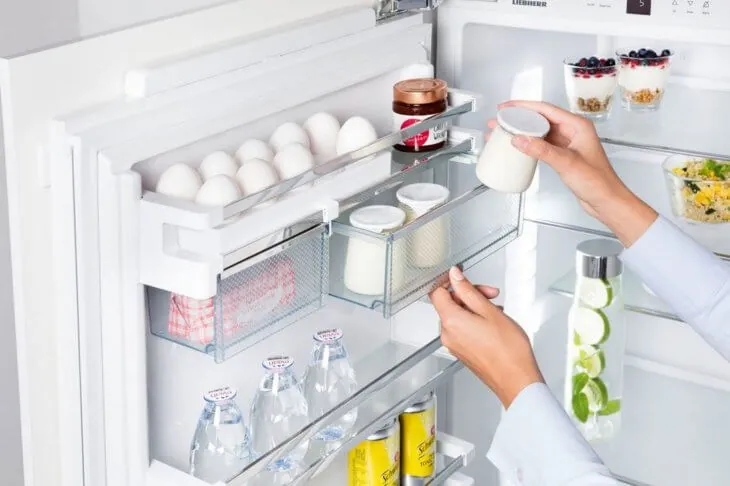 Баночки с продуктами на полке дверцы холодильника