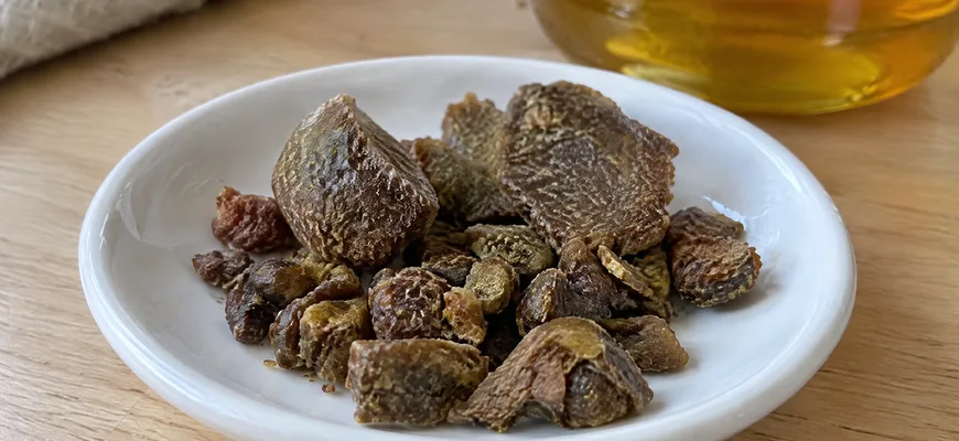 Кусочки сырого прополиса на блюдце рядом с банкой меда