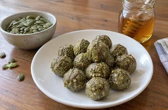 Шарики из молотых тыквенных семечек с медом на тарелке